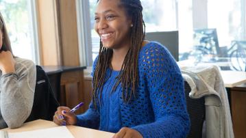 A student smiles while working in a classroom