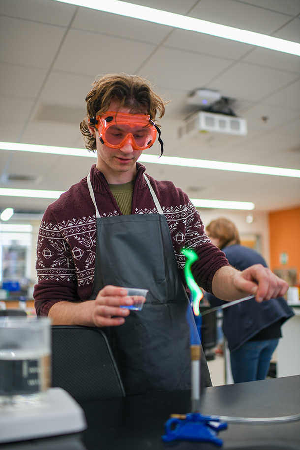 Competitor uses bunsen burner during chemistry competition