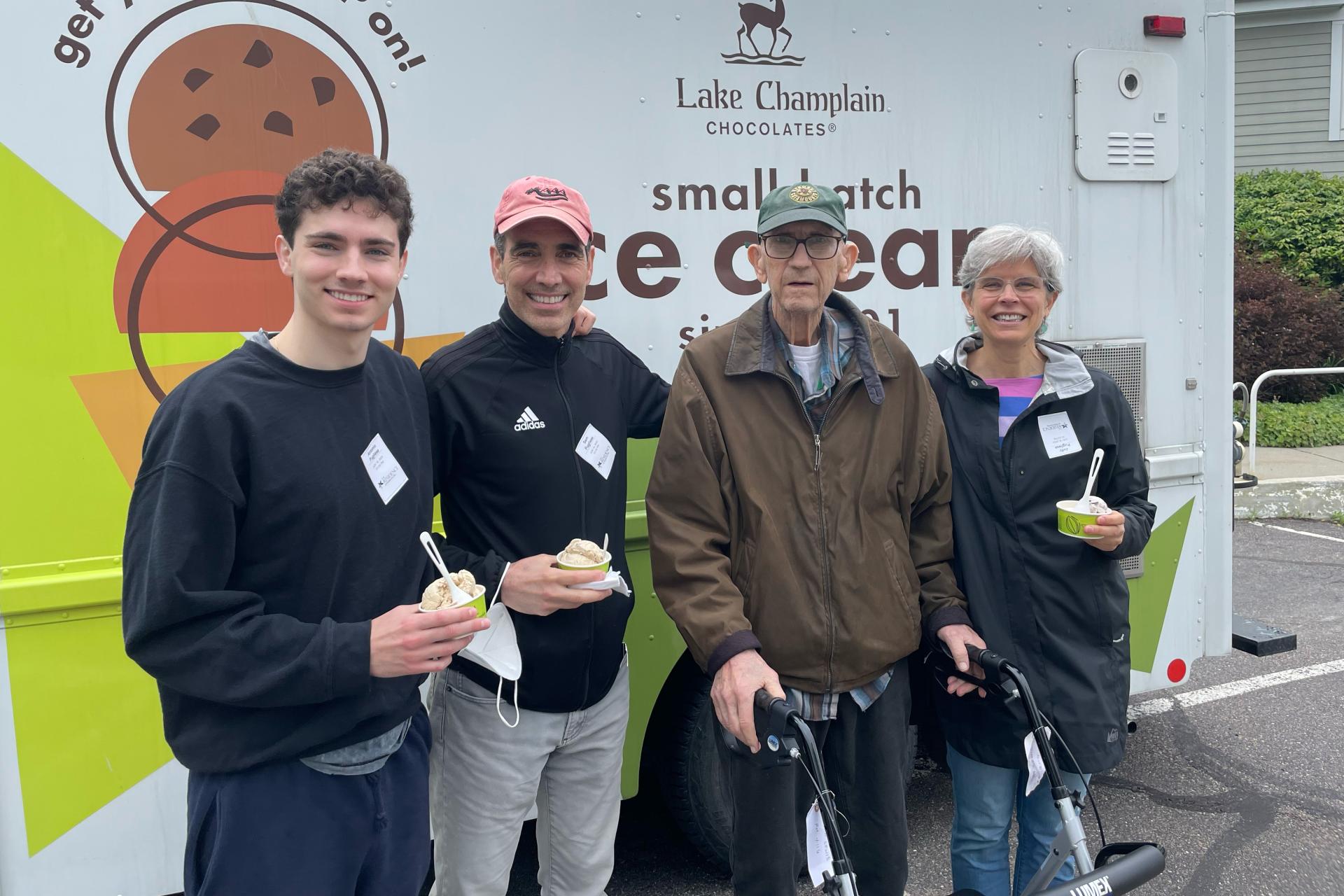 young man standing with middle aged couple and elderly man in front of ice cream truck