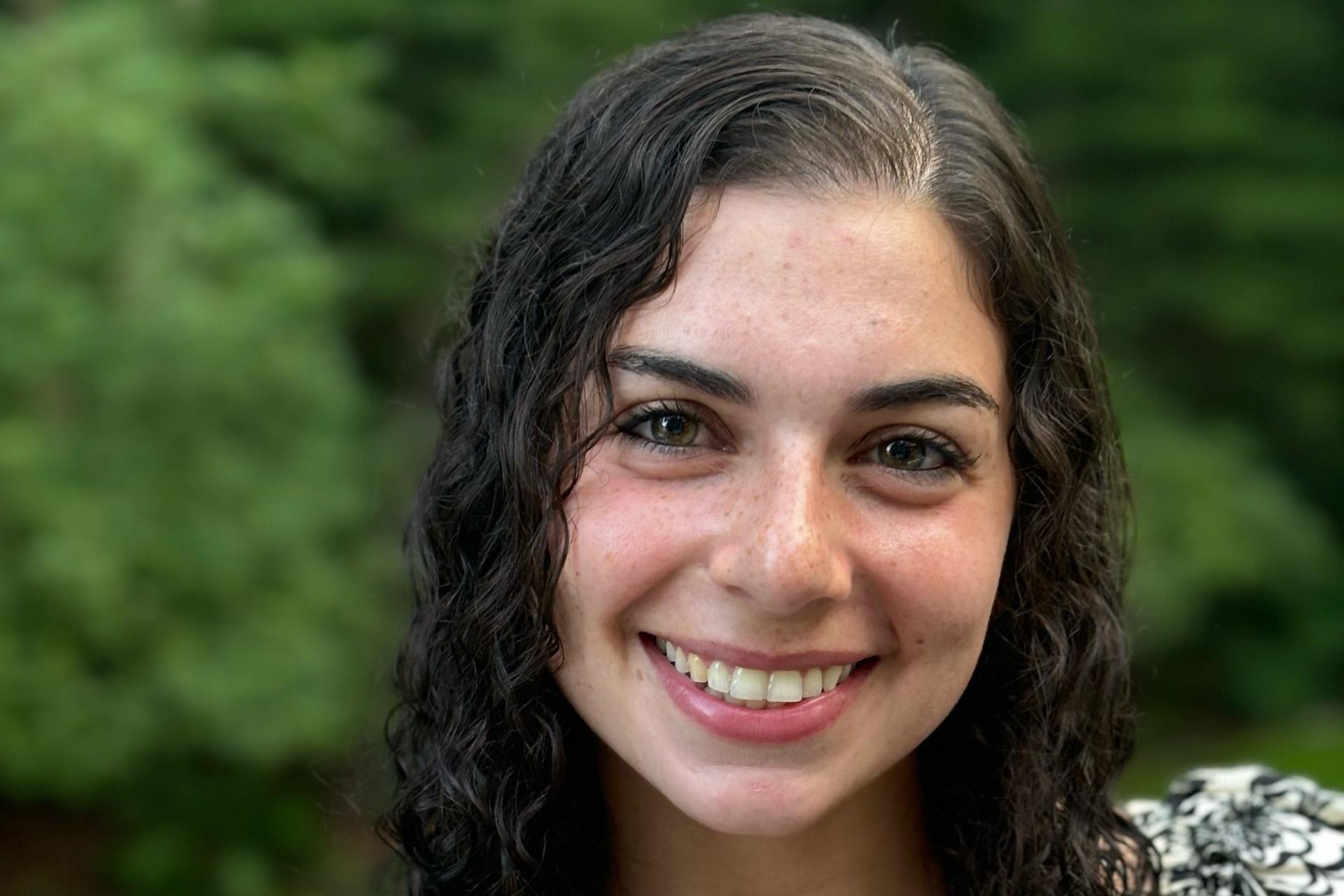close-up of smiling young woman with long, curly brown hair