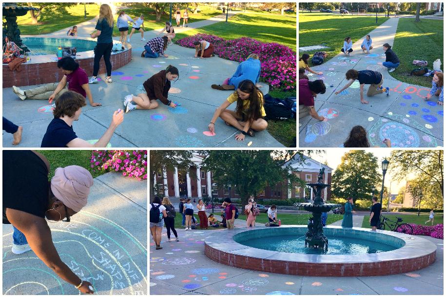 Students in Kelly Becker's class creating art on campus near the fountain on the UVM Green