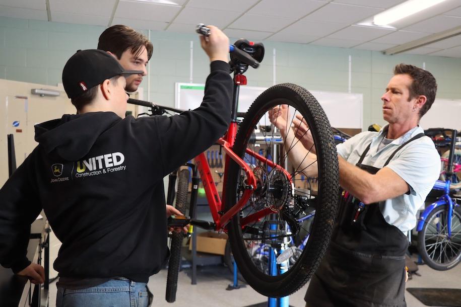Maxfield English works with students involved with Project Bike Tech, a program at Hazen to help students earn credentials and experience in bike maintenance,
