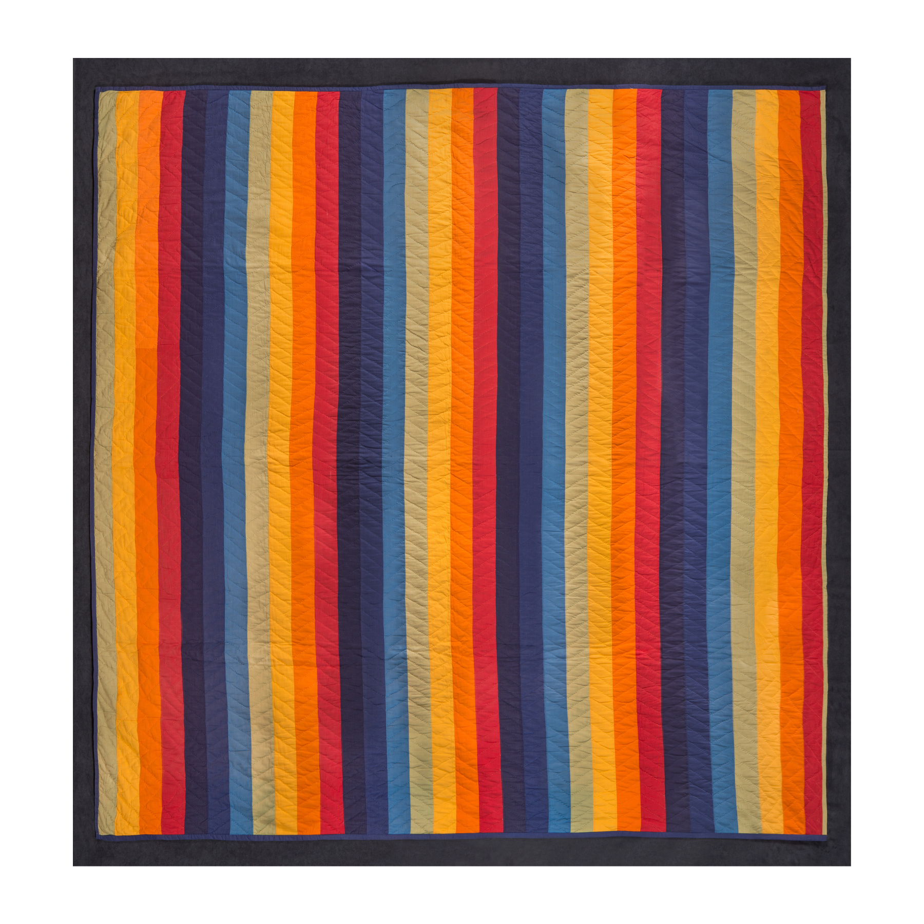 Bright vertical stripes of red-oranges and blues dominate this quilt.