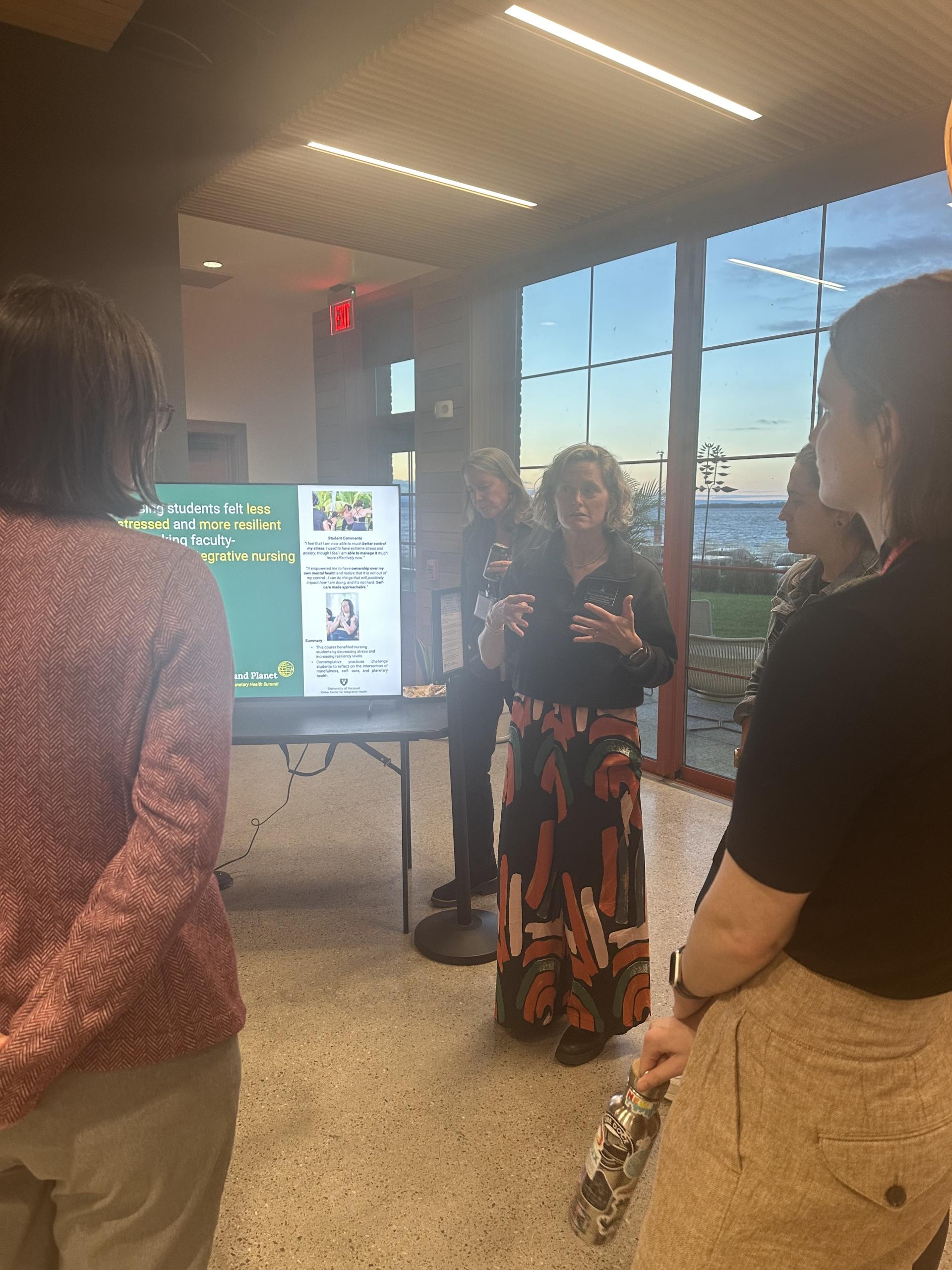 person talking to group at poster
