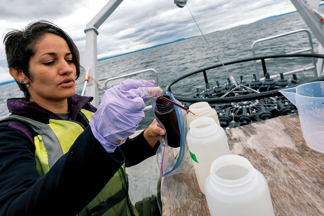 a researcher tests liquid samples on the deck of a boat