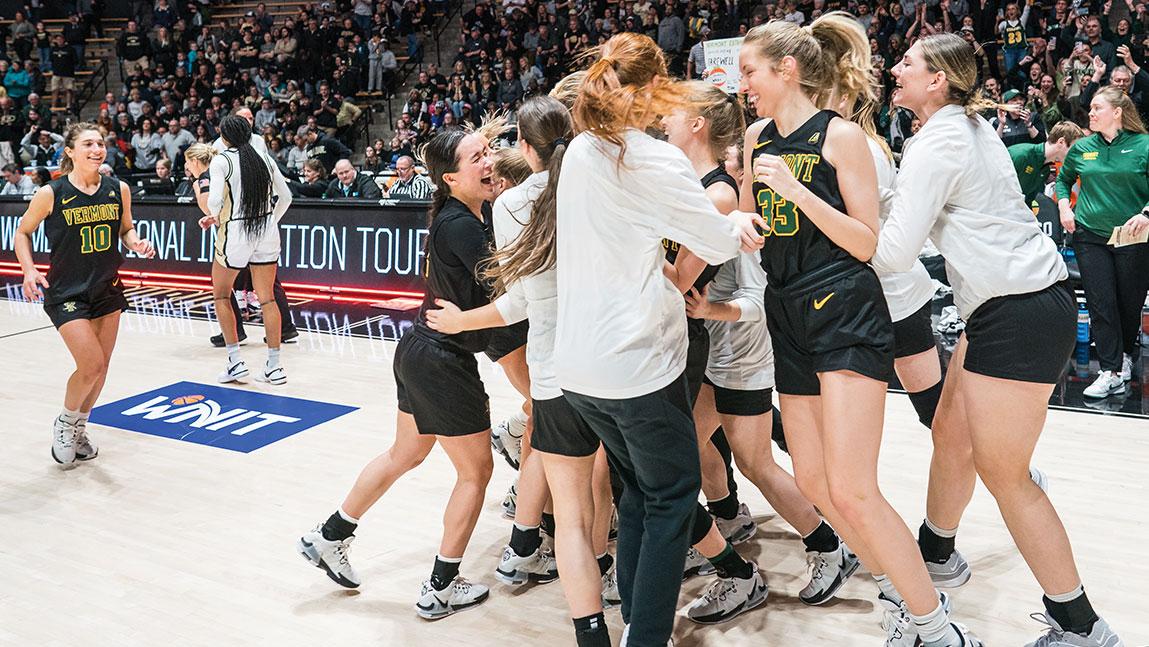 the womens basketball team jumps together in celebration on a basketball court