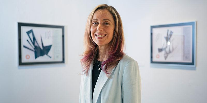 jen karson standing in in a white art gallery in front of two hung pieces