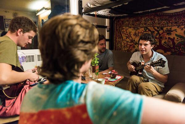 A student plays guitar in his dorm room