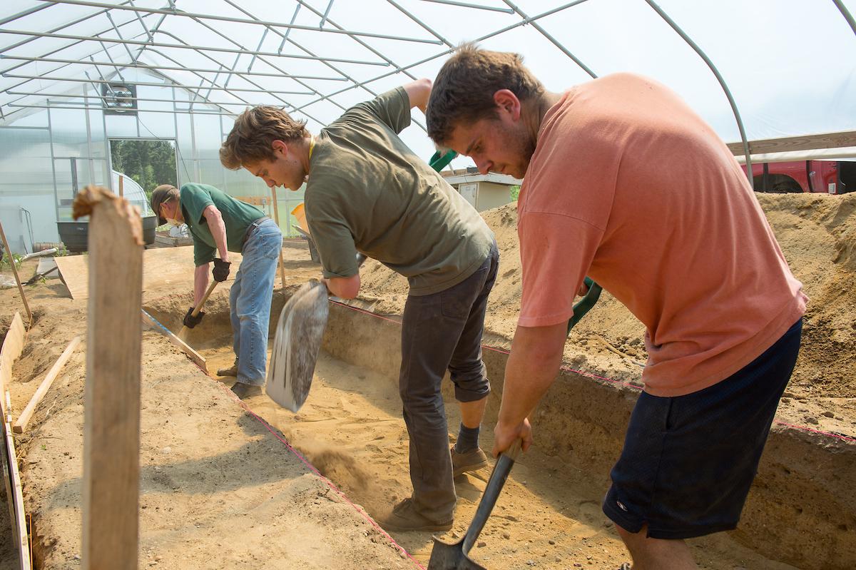 People shoveling garden beds