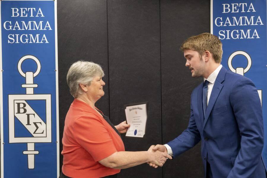 New grossman BGS member shaking hands with the Dean