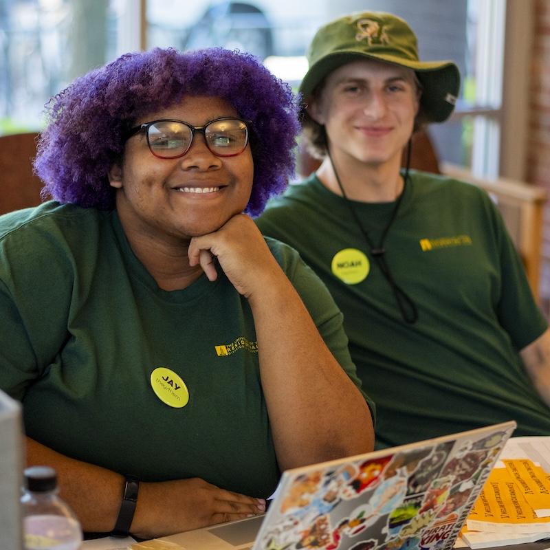 Two resident advisors working the check in desk at move in. 