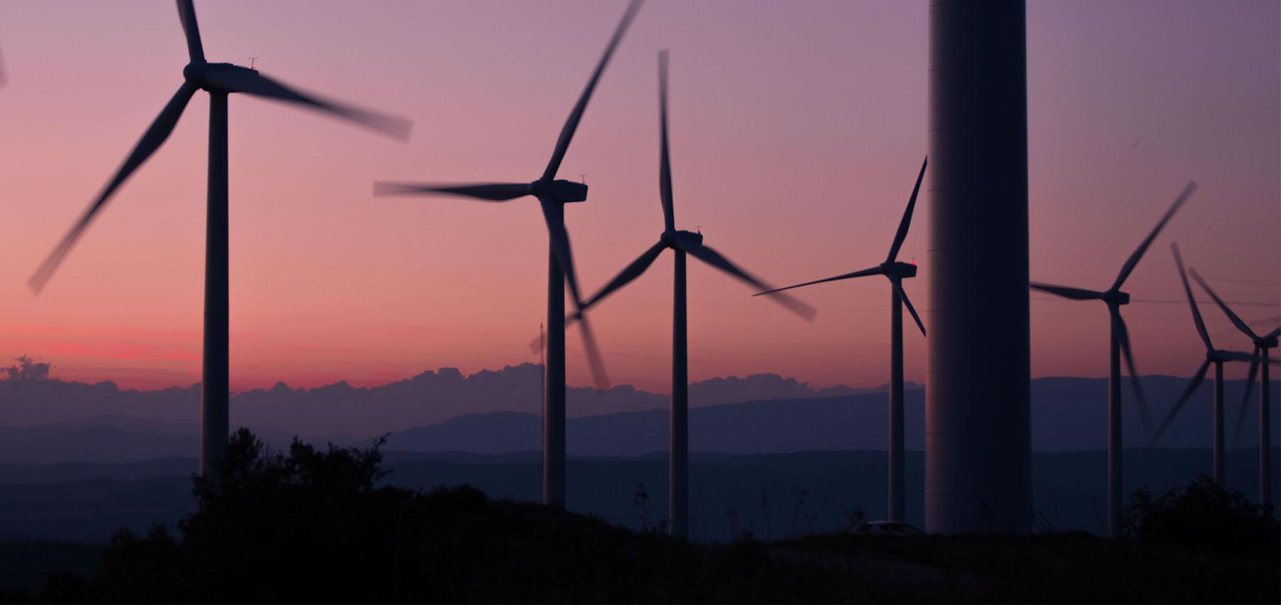 Wind Energy Farm Over a Mountain Sunset 