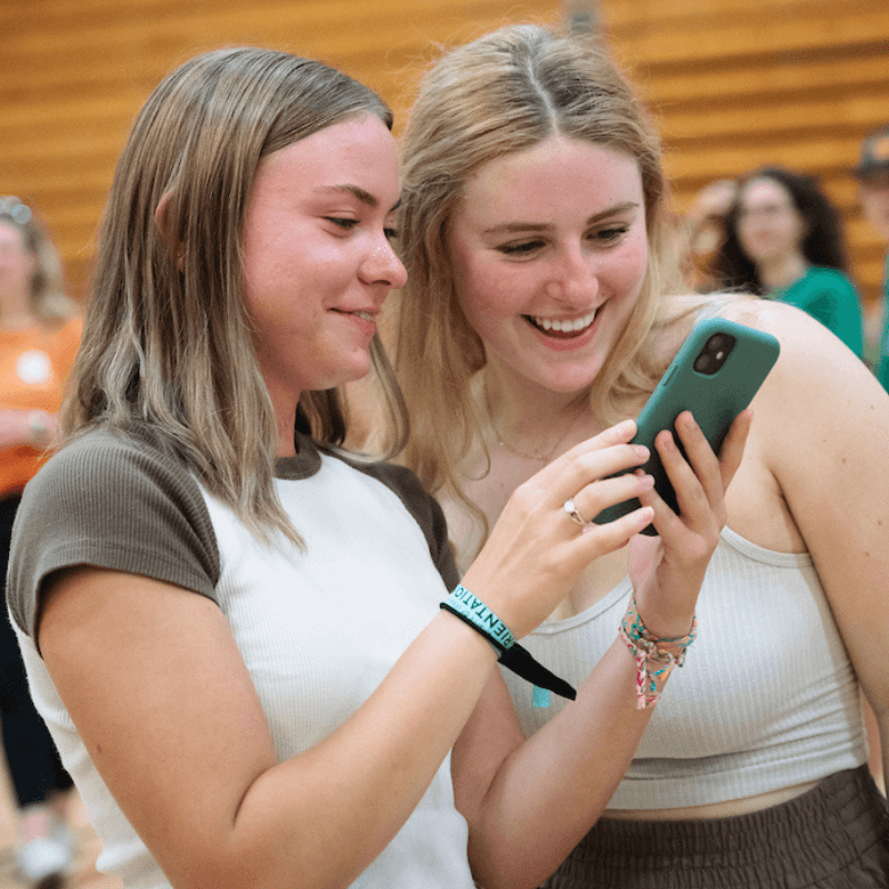 Two students look at a cell phone