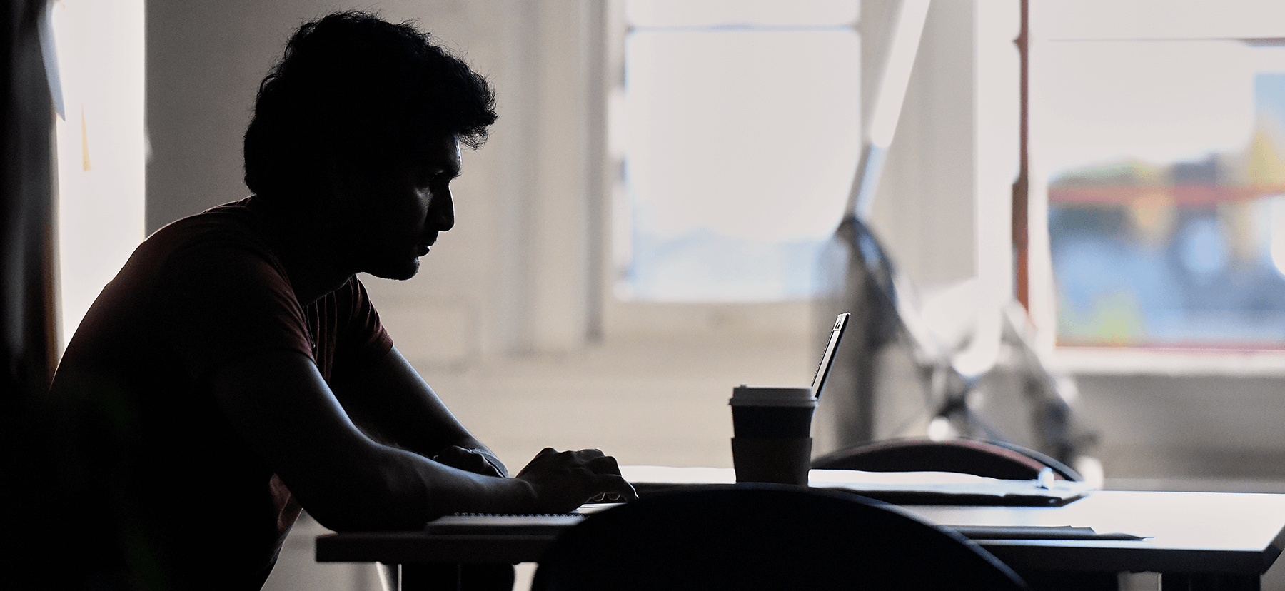 bw shot of lone student studying in silhouette.