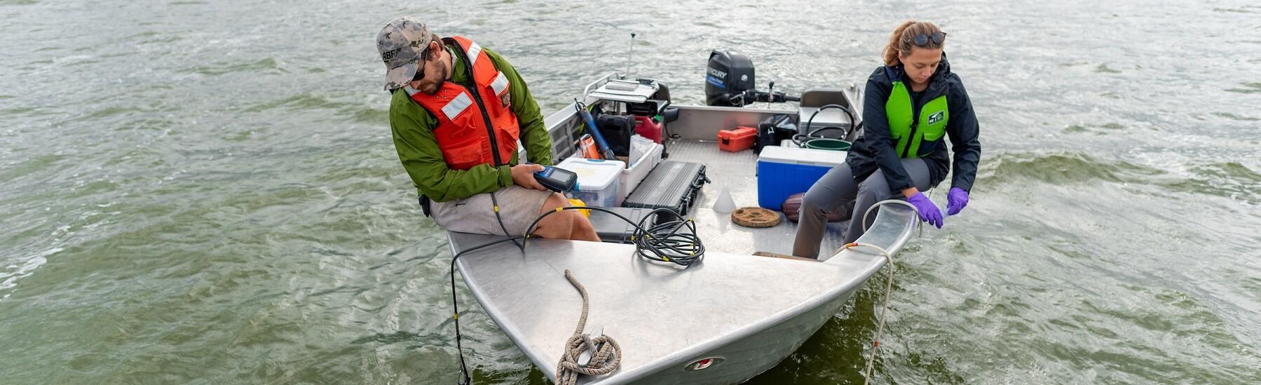 Students on a small boat taking water samples