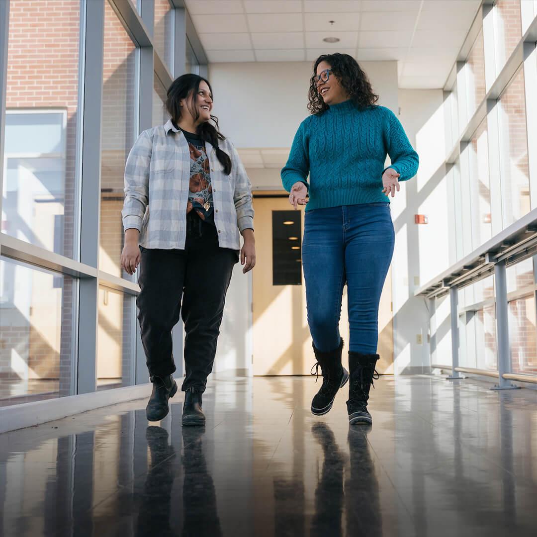 Two students walking down a hallway