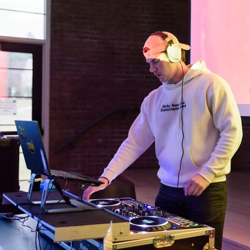 A student DJ with projected lights behind. 