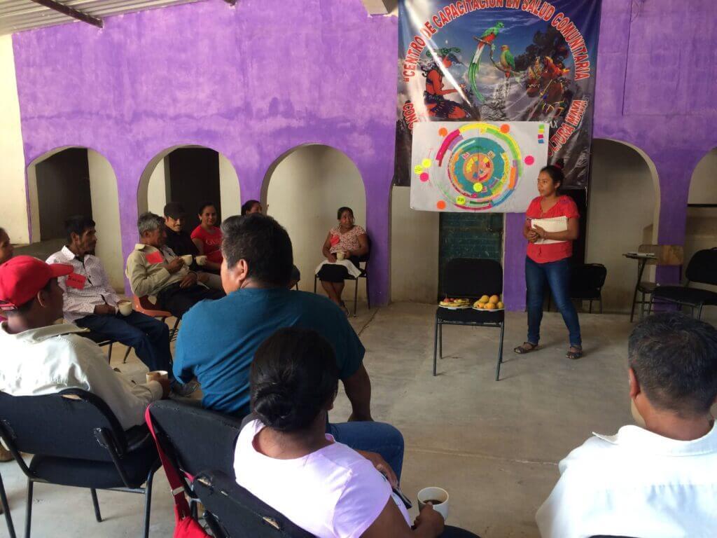 Woman showing the agricultural calendar to a group of farmers in Chiapas Mexico
