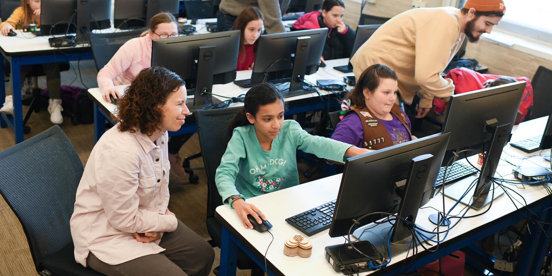 Teachers helping students working with computer-based learning.