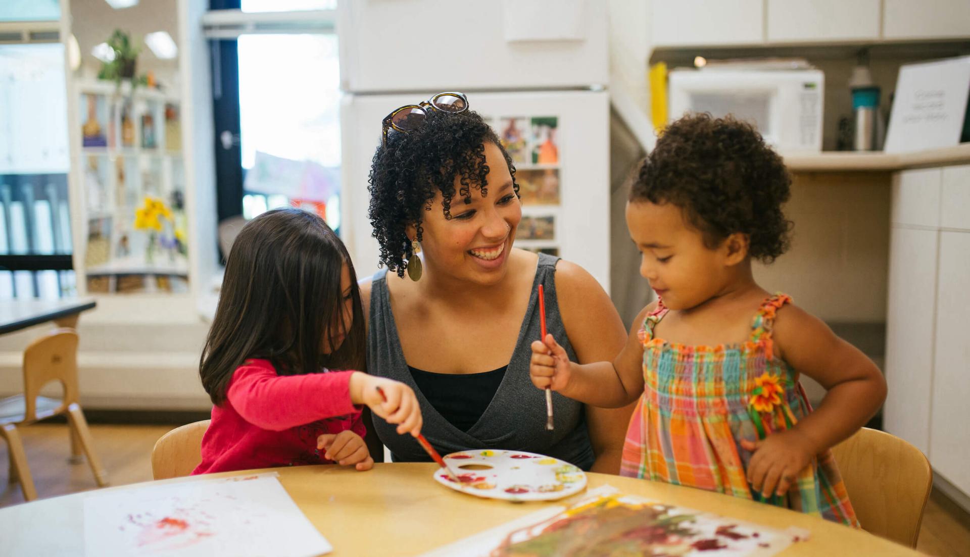 Student teacher works with two students during internship in a preschool.