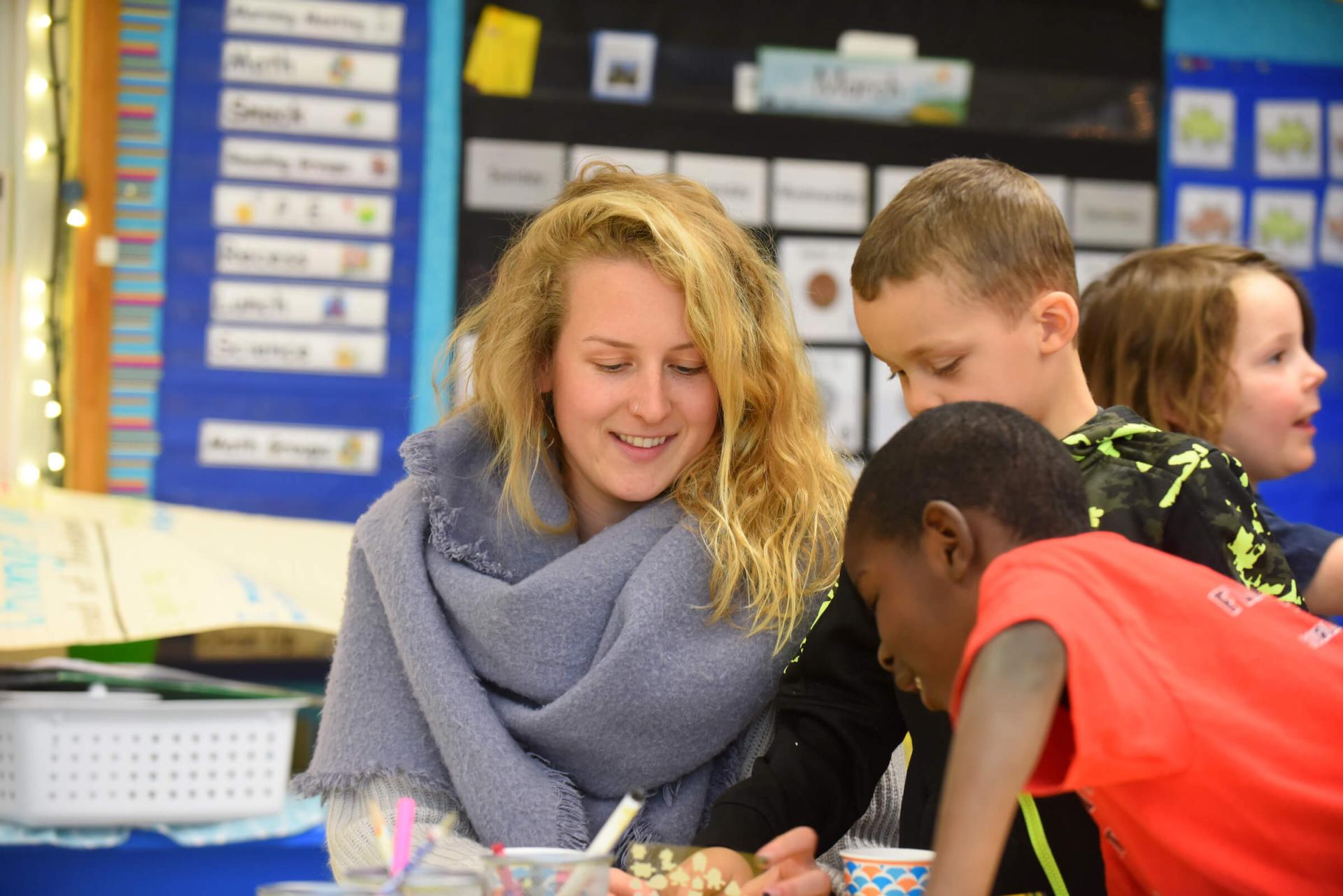 Student teacher works with students in elementary school classroom during internship.