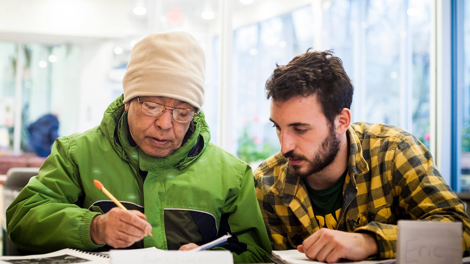 Student helping a new American through service-learning in the local community.