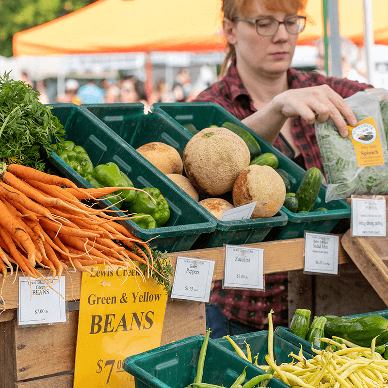 Farmers Market Booth with carrots and other vegetables