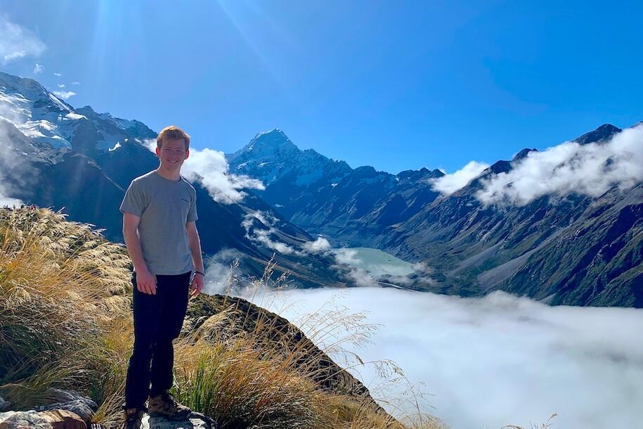 Leggatt Kerek '24 in New Zealand surrounded by majestic mountains on a beautiful sunny day.