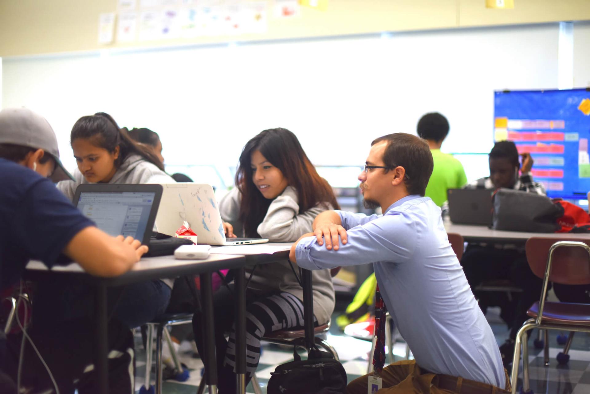 Winooski High School Teacher Tom Payeur working with students in his classroom.