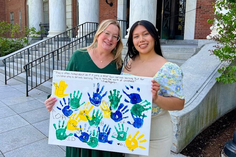 AMP graduate Magdalena Cataldo G'24 and her faculty mentor Jen Hurley hold a poster given by students in Magdalena's internship.