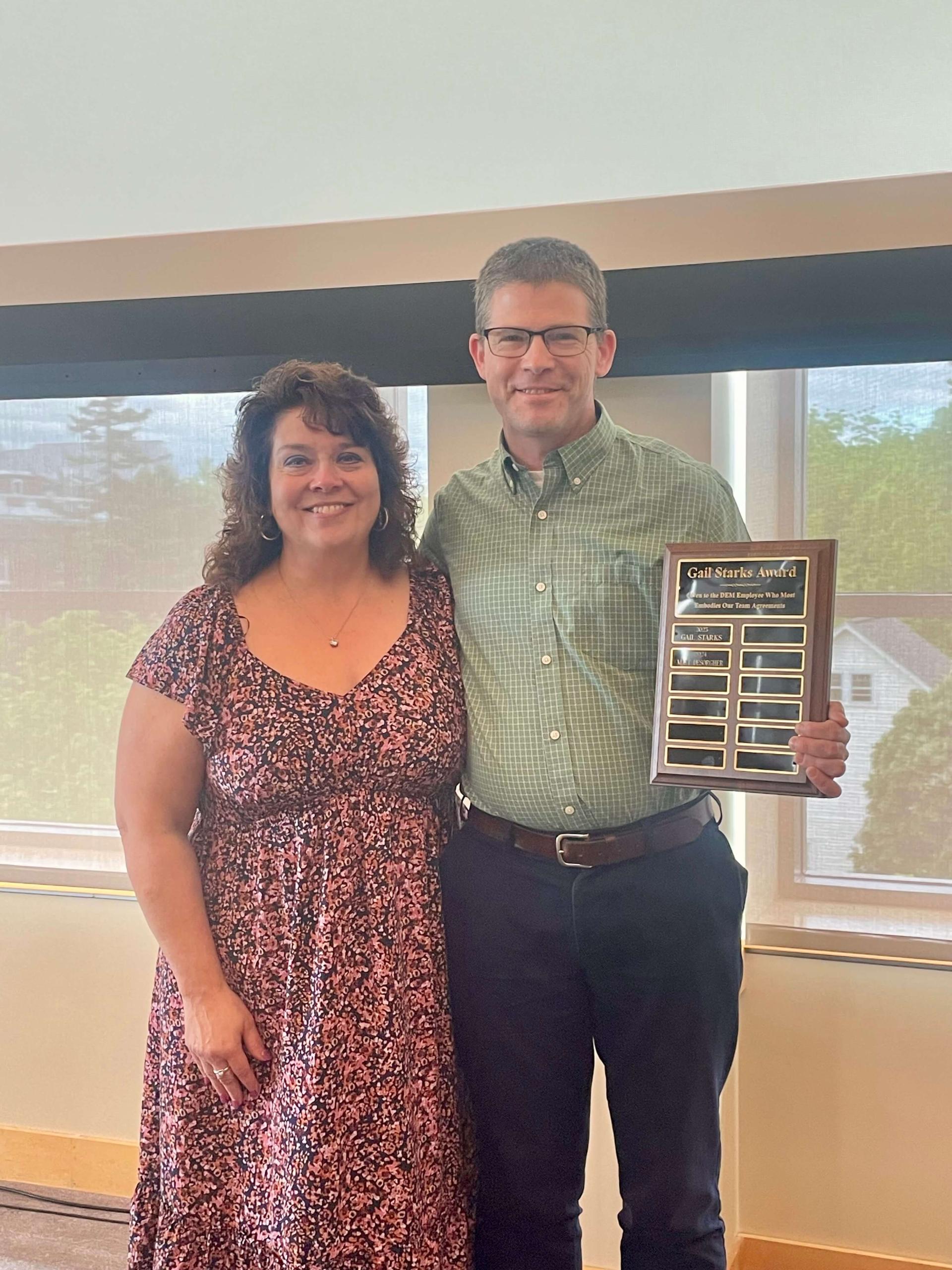 Matt DeSorgher holding the award and posing for the photo with an unknown female