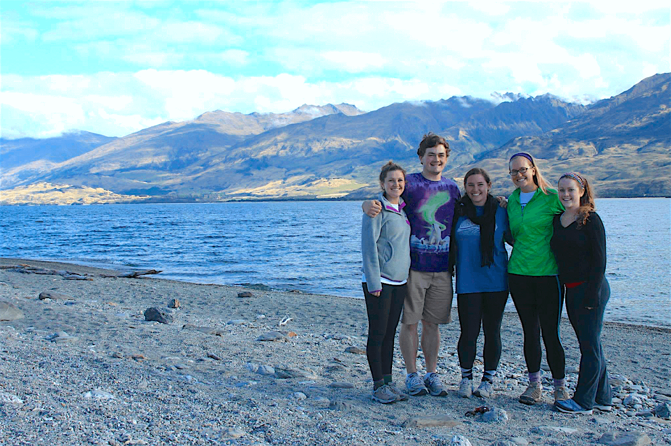 Students standing together in front of a lake and majestic mountains in New Zealand.