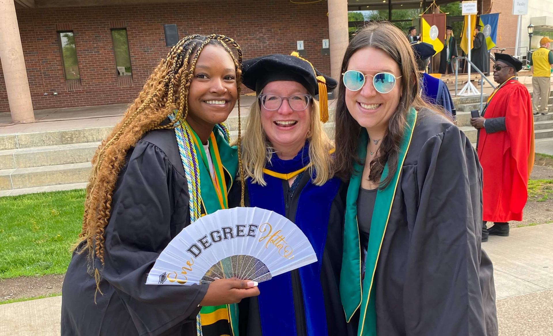 Sandra King with faculty member Jen Hurley and another student smile at the line up for Commencement.