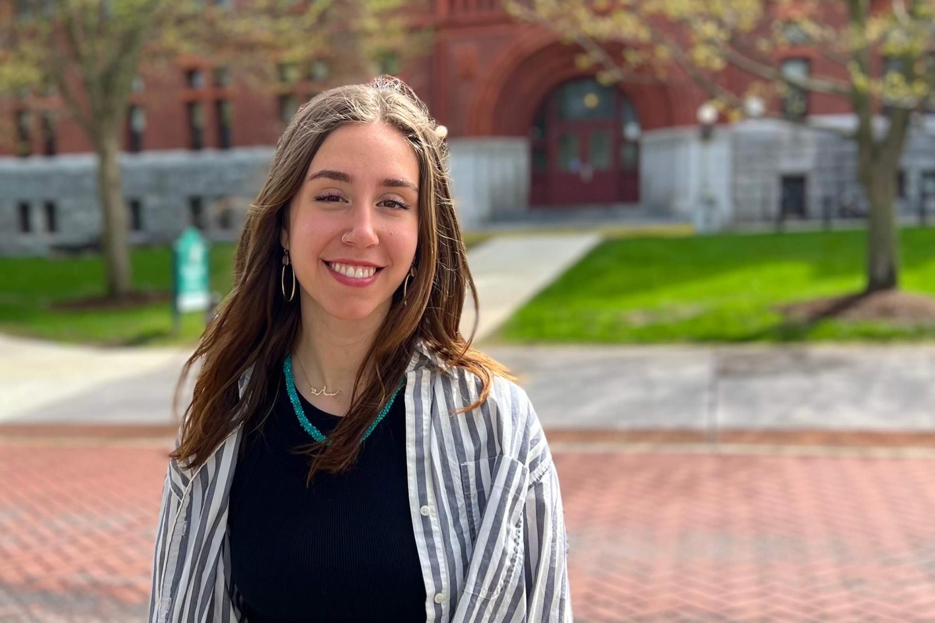 Sarah Sarrouf smiles stadning in front of Williams Science Hall on the UVM campus.
