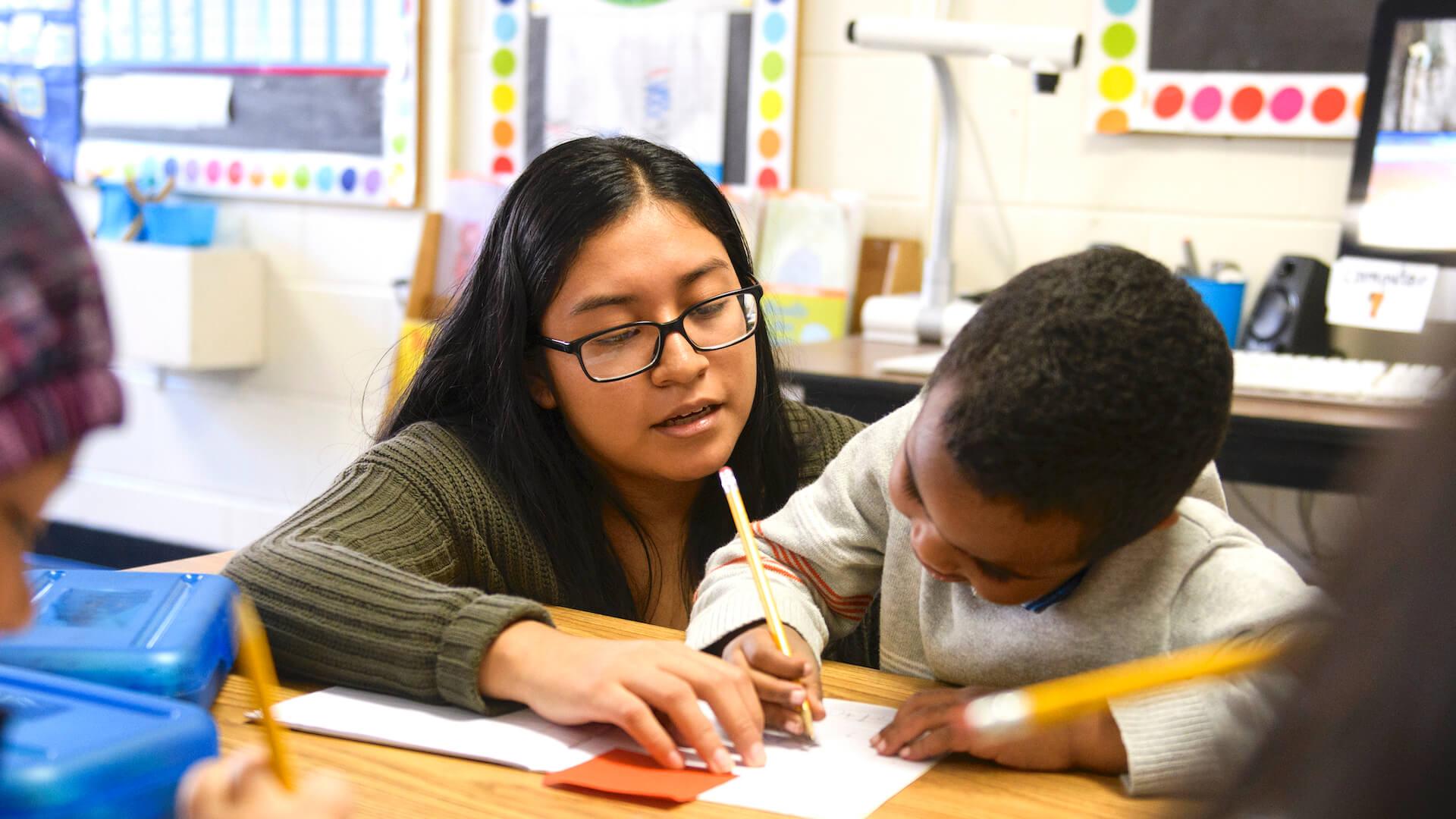 Student teacher working with student in school internship.