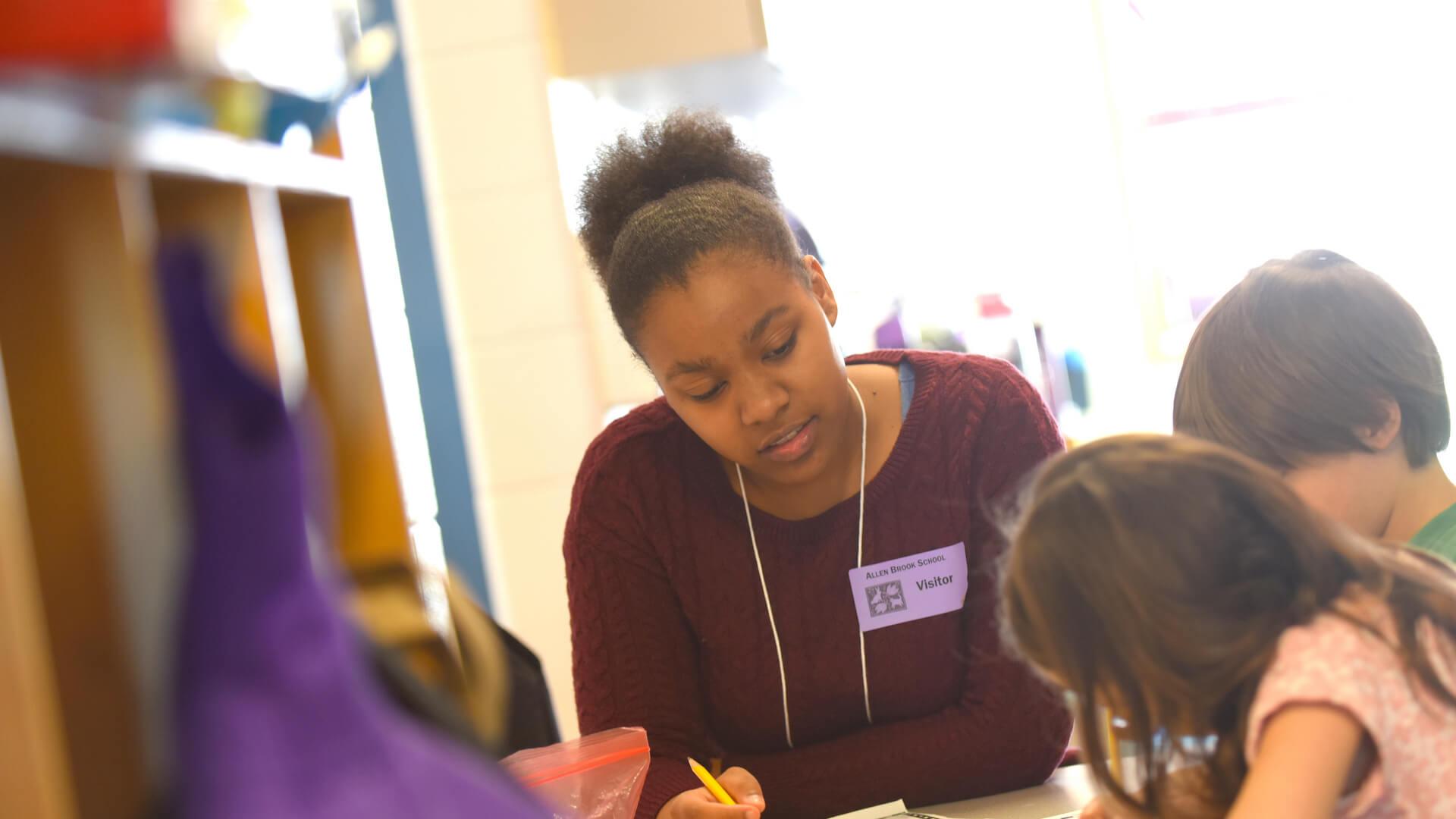Student teacher works with students in a local school classroom.