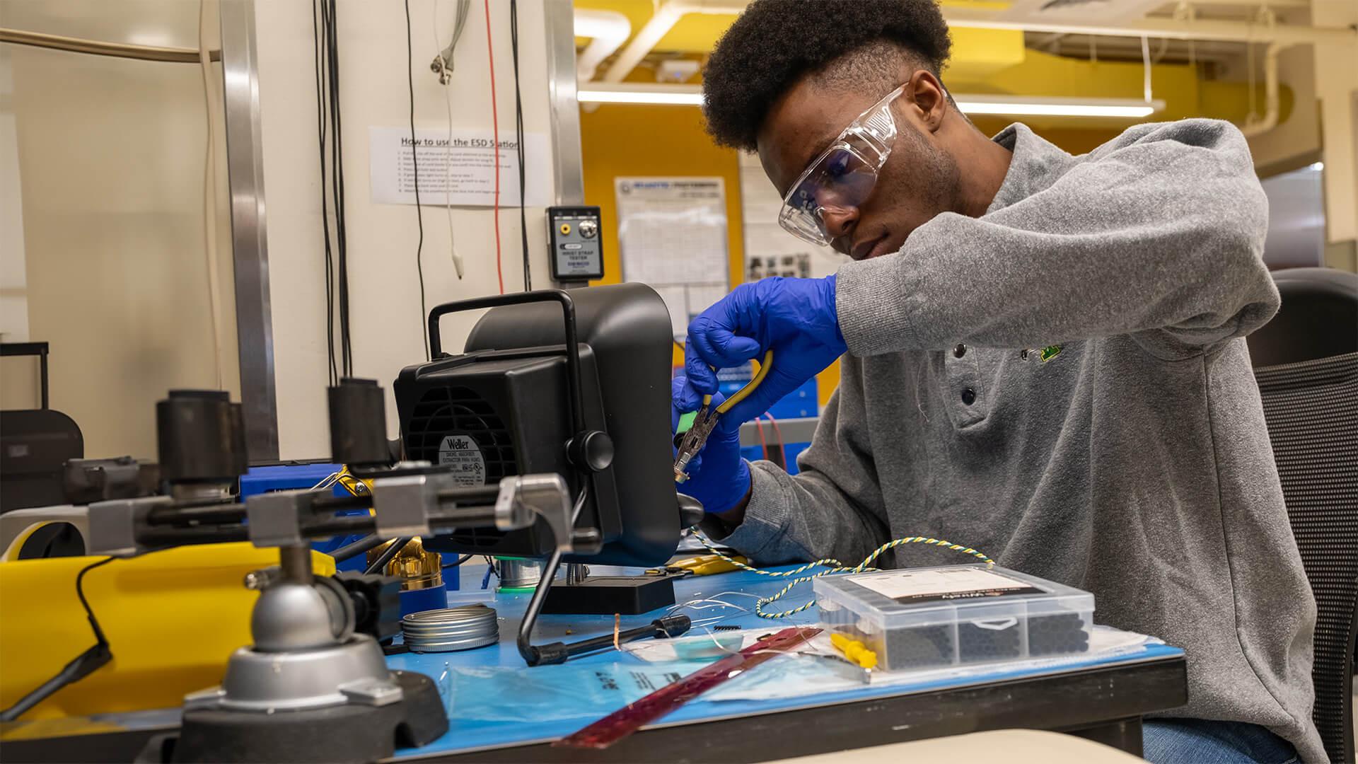 CEMS student working on an electrical engineering project in a lab