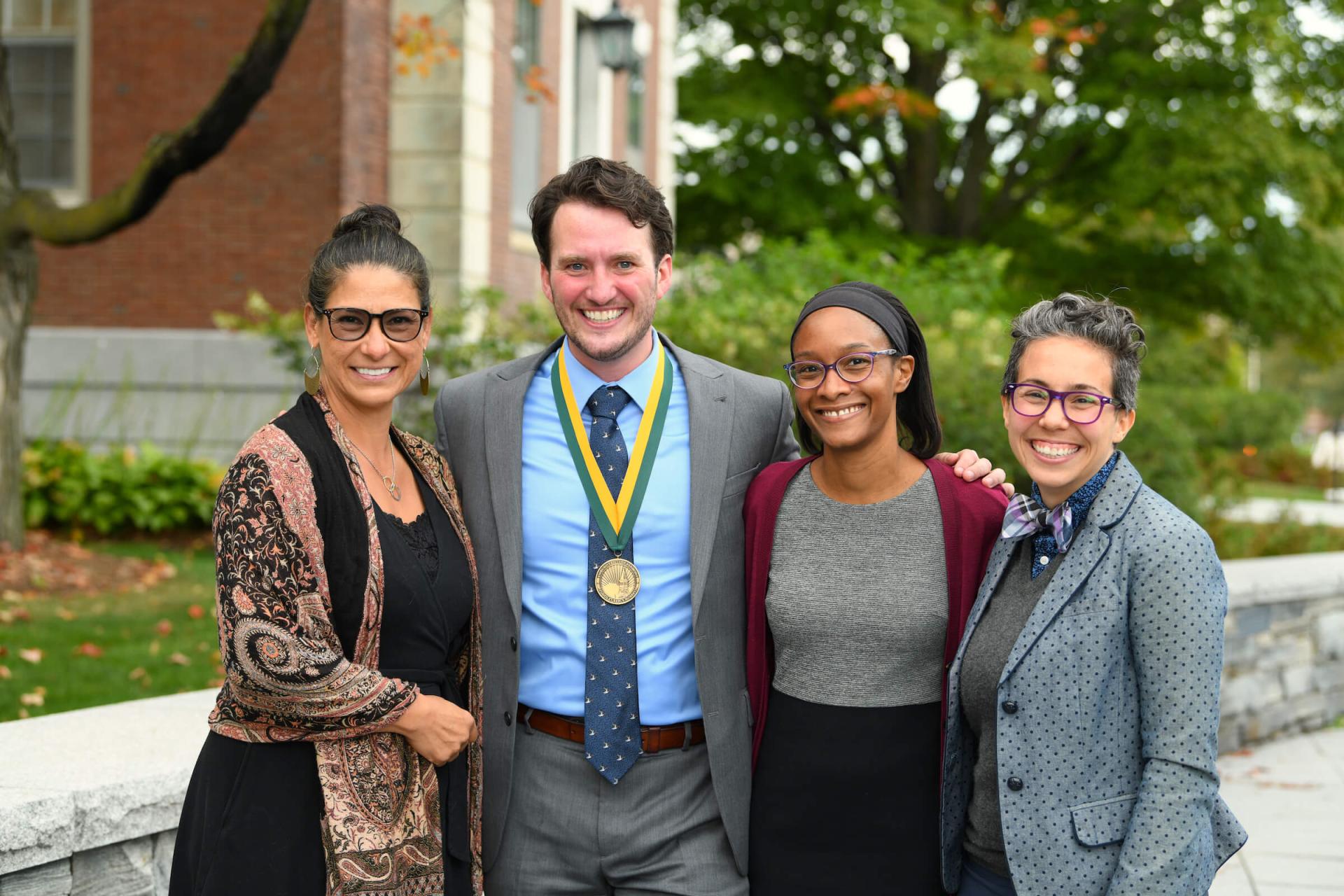 HESA faculty members with a student in front of Waterman Building.