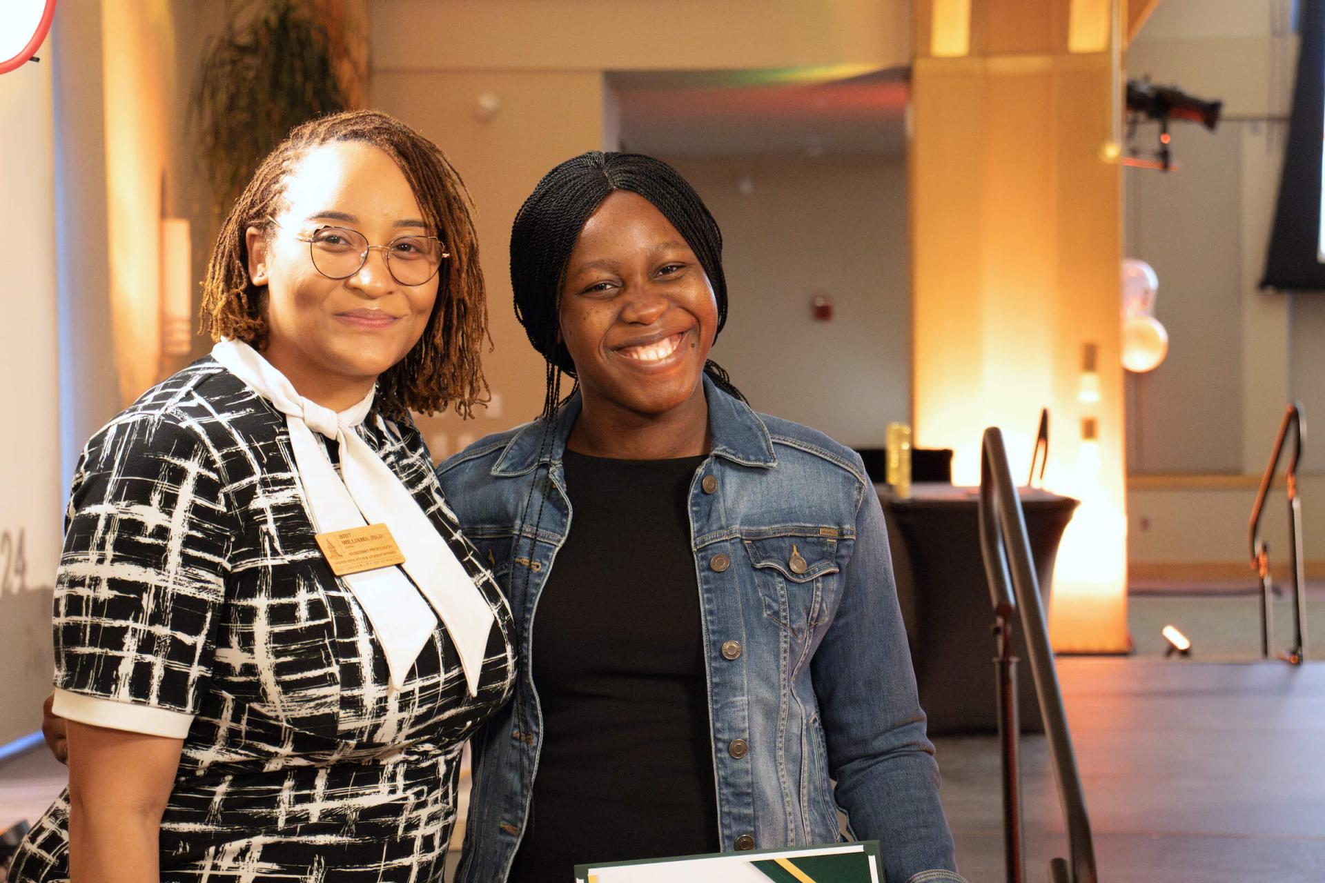 HESA faculty member Brit Williams and her mentee Joy Emmanuel together smiling at awards reception.