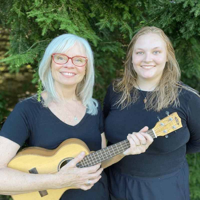 Two woman, one holding a ukulele 