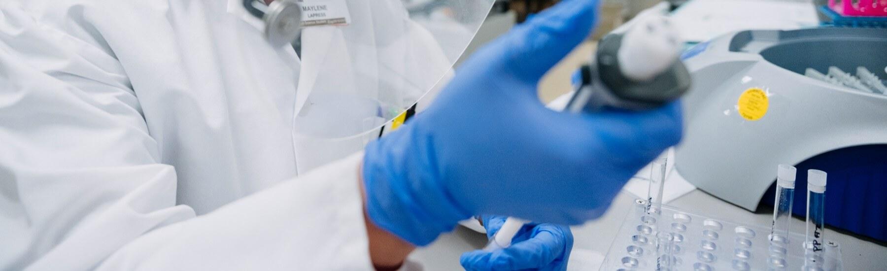 Med lab scientist using pipette in lab