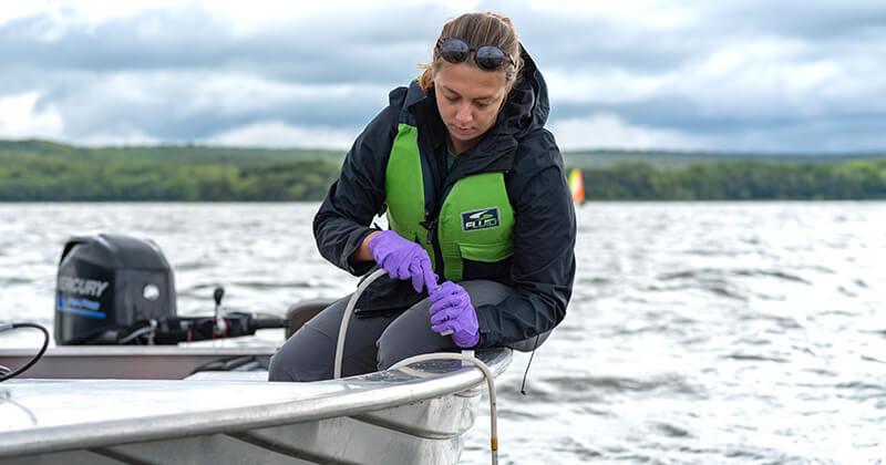 Student researcher on a boat on Lake Champlain