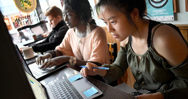 Students working on their laptops at a cafe