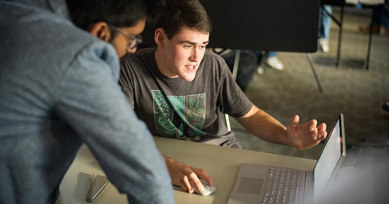 Student and professor discussing computer code