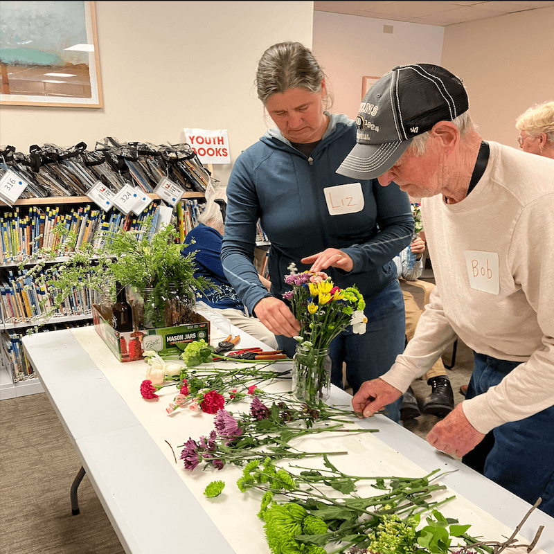 Two people crafting flower bouquets 