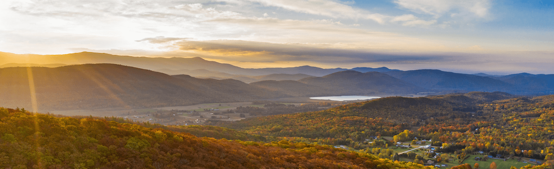 Sunrise Image over Monkton Vermont in the fall, view of fall foliage on mountains with hint of a lake in the background.