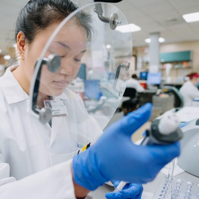 A medical laboratory scientist observes a sample in the lab