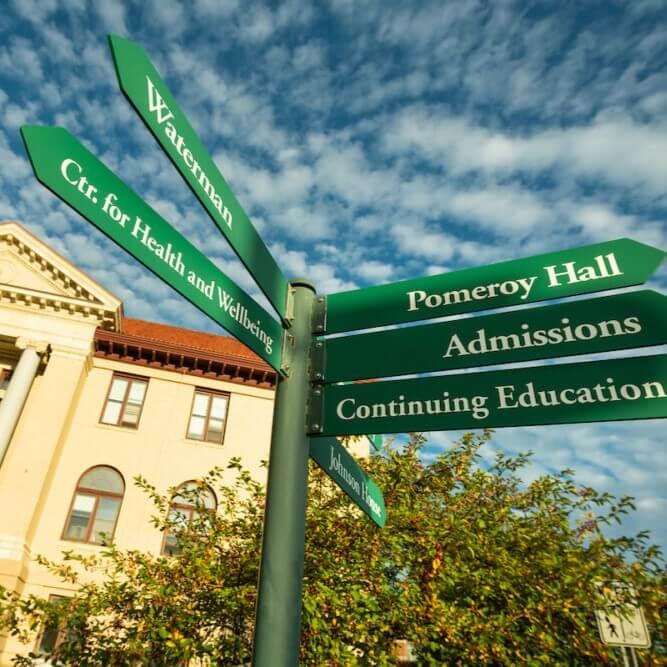 Directional sign displaying names of buildings and offices on UVM campus