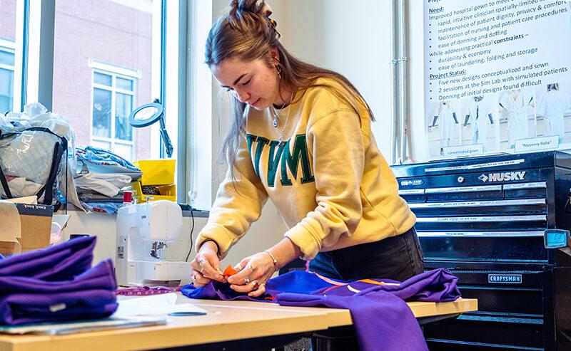 A student in the Center for Biomedical Innovation works on the prototype for a reengineered hospital gown