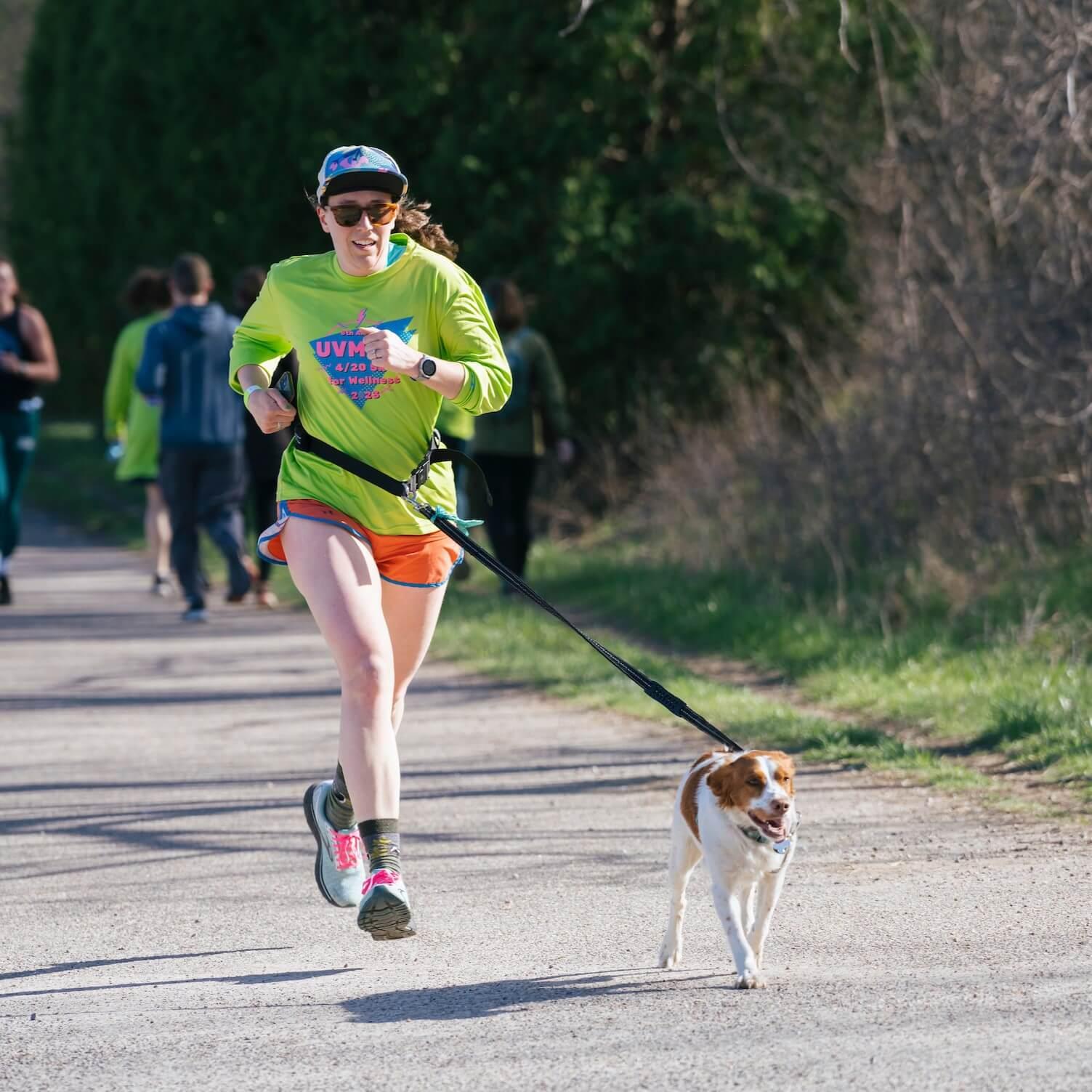 Woman runs with her dog in the Wellness 5k